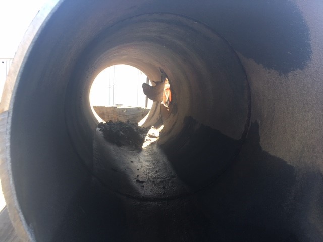 Light shines through the hole in the damaged pipe.