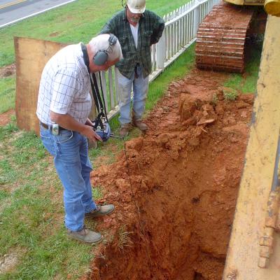 An experienced field engineer listens for a water leak.
