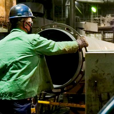 A foundry worker inspects the diameter and ovality of a 36-inch Ductile iron pipe.