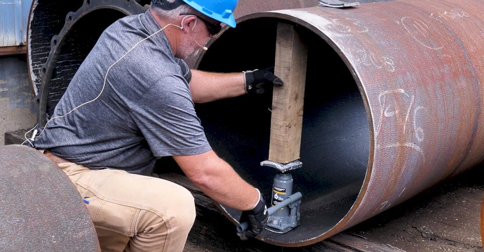 Position the shims, jack, and wood so that they align vertically with the minimum diameter.