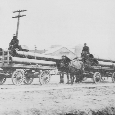 Horses pull loads of iron pipe, circa early 1900's.